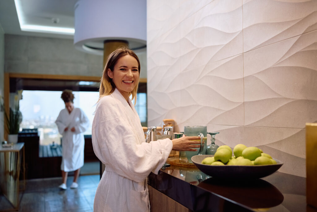 Woman reaching for fresh lemon juice at a juice bar in a wellness facility.