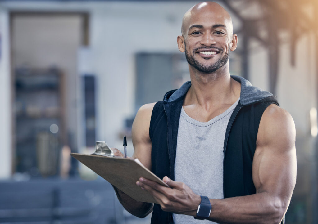 Gym owner looking at the camera and smiling, holding paperwork.
