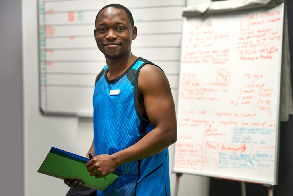 Personal trainer in his office in front of a board.