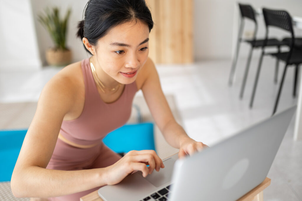 Female fitness instructor working on her laptop.