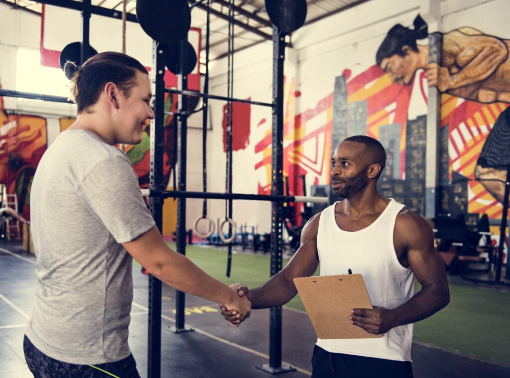 Gym owner shaking hands with business partner