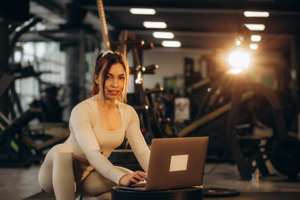 Female sport instructor trainer Caucasian woman slim sportswoman girl influencer teaching online workout on laptop fitness class in gym training video tutorial yoga on digital device in sports club Female sport instructor trainer Caucasian woman slim sportswoman girl influencer teaching online workout on laptop fitness class in gym training video tutorial yoga on digital device in sports club