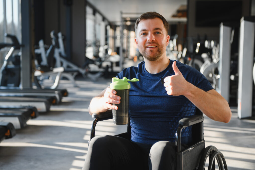 Gym member in wheelchair showing thumbs up