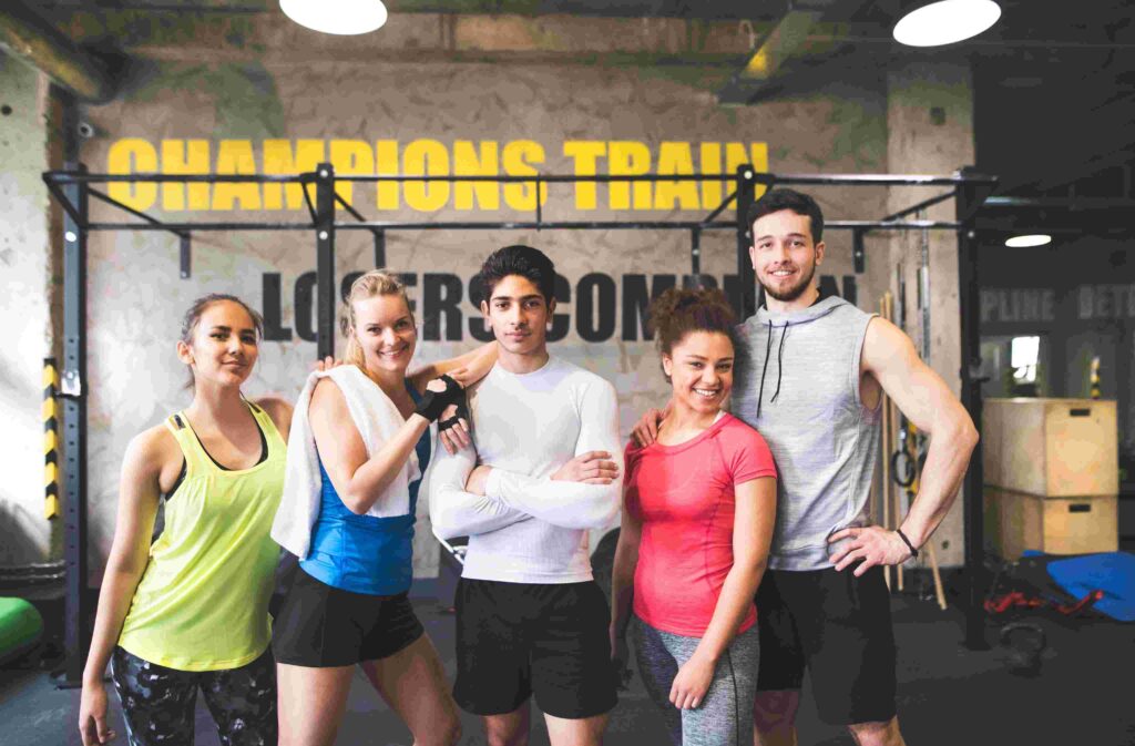Group of diverse young athletes posing in a fitness studio highlighting inclusive and modern gym branding.