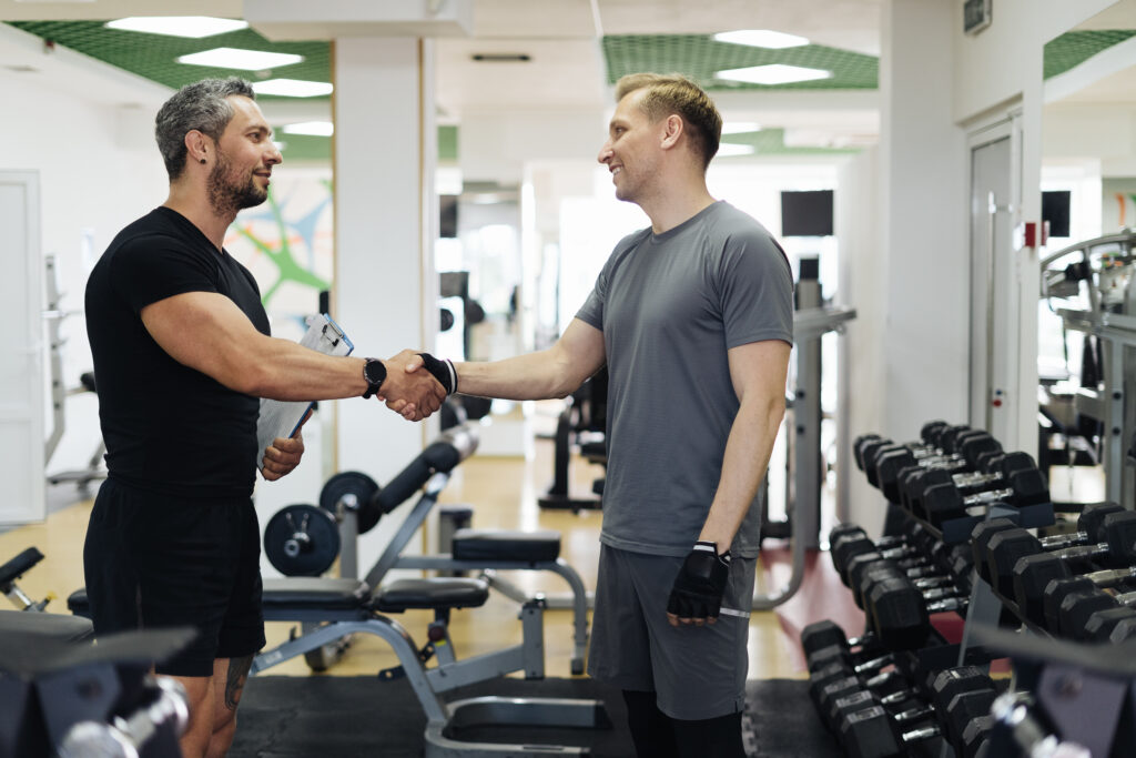 Gym owner and fitness instructor shaking hands